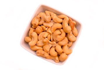 Cashew nuts on bowl on a white background seen from above