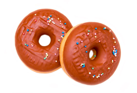 Donuts with chocolate and colored sugar on a white background seen from above