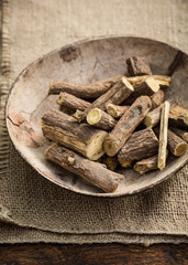Licorice roots on wooden bowl on a jute bag