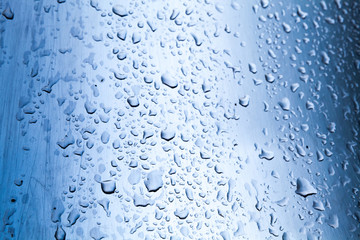 Curved stainless steel surface with water drops