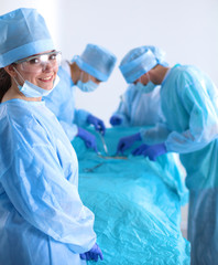 Team of surgeon in uniform perform operation on a patient at