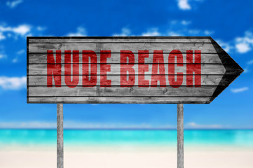 Red Nude Beach wooden sign with on a beach background