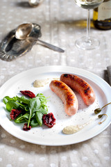 Grilled sausages with salad on a white plate
