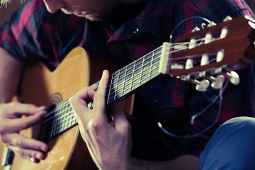 Young man playing acoustic guitar during a concert. - Vintage co