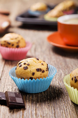 muffins with chocolate in colorful tins served with a cup of cof