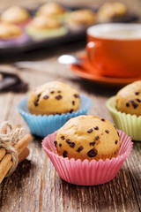 muffins with chocolate in colorful tins served with a cup of cof