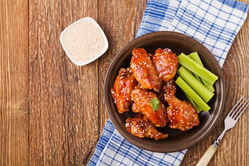 Baked chicken wings in honey sauce sprinkled with sesame seeds.