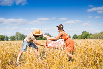 Young man and woman having fun in summer wheat field