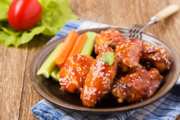 Baked chicken wings in honey sauce sprinkled with sesame seeds.