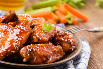 Baked chicken wings in honey sauce sprinkled with sesame seeds.