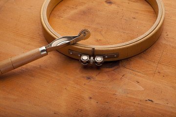 Plow with needlework ring craft concept on wooden texture