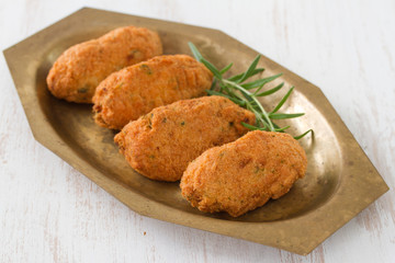 codfish croquettes on dish on white background