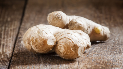 Fresh ginger on old wooden table, selective focus