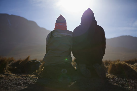 Two backpackers watching sunrise in Atacama desert