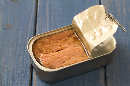 canned tuna on blue wooden background