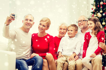 Obraz na płótnie Canvas smiling family with camera at home