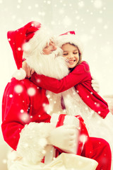 smiling girl with santa claus and gift at home
