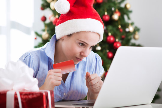 Girl with santa cap shopping online at home