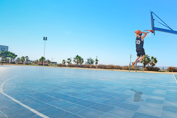 two-handed slam dunk in a blue playground