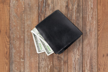 close up of dollar money in black wallet on table