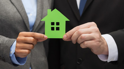 businessman and businesswoman holding green house