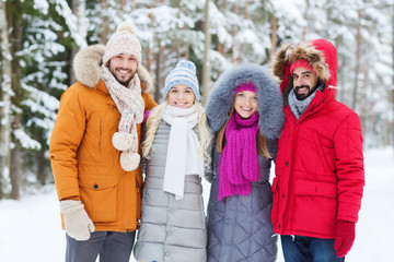 group of smiling men and women in winter forest