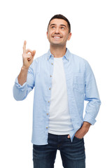 smiling man pointing finger up