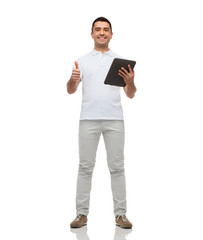 smiling man with tablet pc showing thumbs up