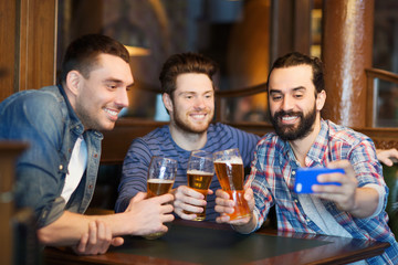 friends taking selfie and drinking beer at bar