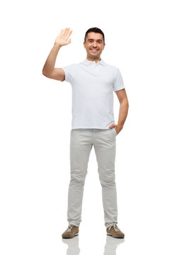 smiling man in blank white t-shirt waving hand
