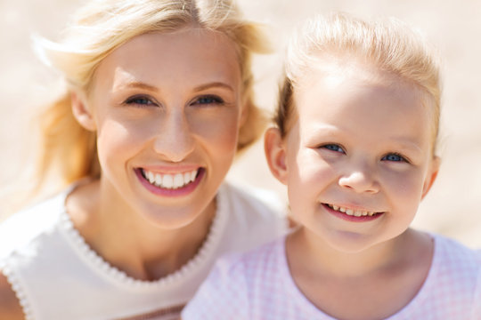 happy mother and little daughter on summer beach