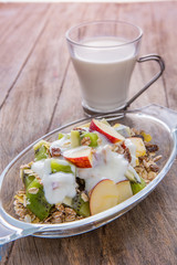 Healthy bowl of muesli, apple, fruit, nuts and milk for a nutrit
