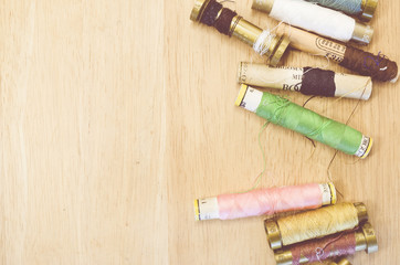 old sewing thread spools on wood background