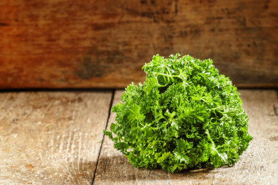 Fresh curly parsley on an old wooden background in rustic style,