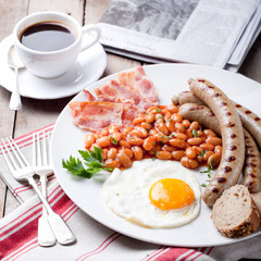 Fried egg with beans, bacon and grilled sausages