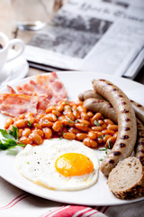 Fried egg with beans, bacon and grilled sausages