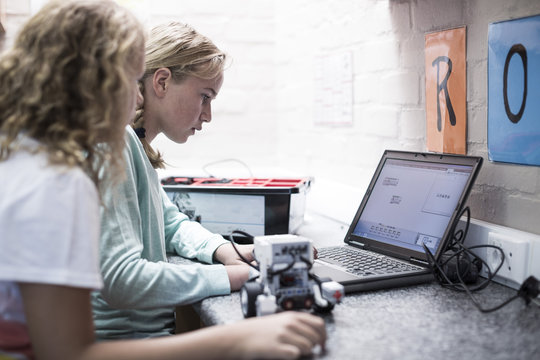 Two schoolgirls with laptop in robotics class