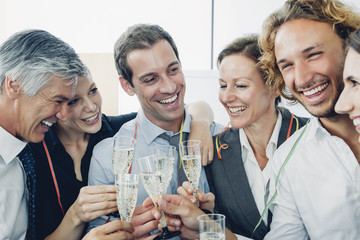 Group of business people raising a toast with champagne at office