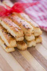 Bread Salty Grissini Sticks with sesame and flax seeds prepared for New Year's Day with red ribbon and red Christmas decorations