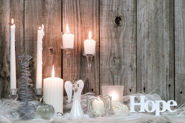 Christmas candles, angel and Hope by rustic antique wood background