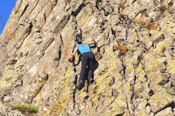 Young lady climbing the rocks in mountain