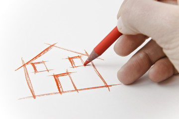 Hand drawing an house with a pencil on white sheet