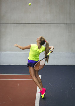Young woman playing tennis in an indoor tennis center