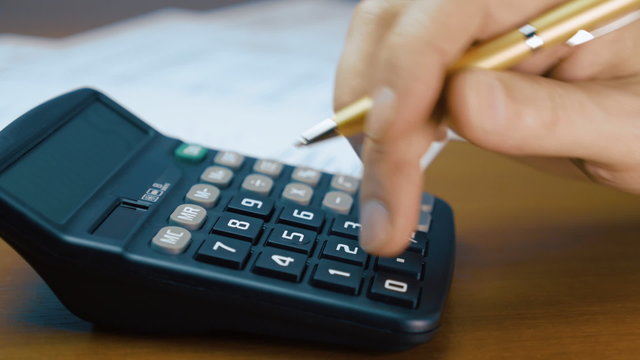 Businessman analyzing the market and considers on the calculator