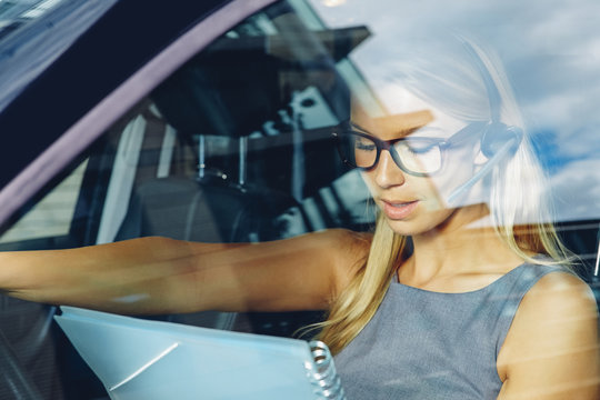 Businesswoman wearing bluetooth wireless device in car