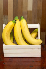 bananas in the basket on wooden table. © nouvoice