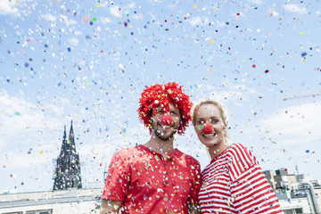 Germany, Cologne, young couple celebrating carnival dressed up as clowns