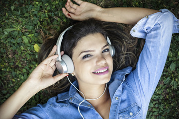 Beautiful girl listening to music in a park