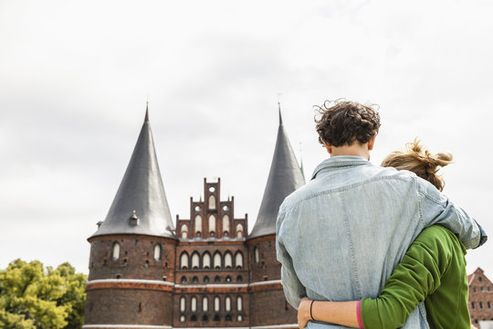 Germany, Luebeck, couple embracing in front of the Holsten Gate