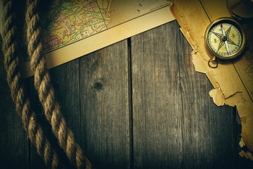 Antique compass and rope over old map